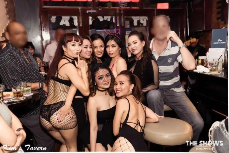 About 9 ho-chi-minh-bar-girls-dressed-in-black-taking-care-of-their-two-male-customers