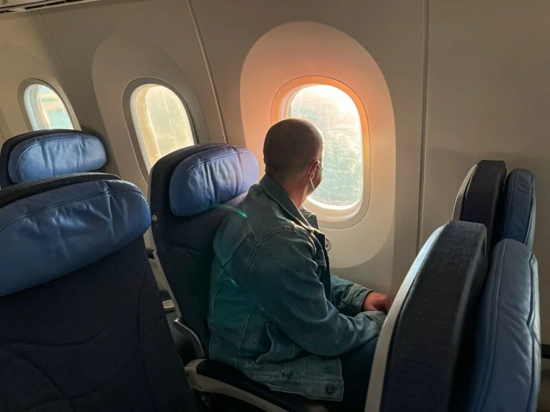 Ultimate Guide On Where To Watch Premier League Matches in Ho Chi Minh City 2 Man looking through a window traveling by plane, sitting, aircraft, airplane, seats